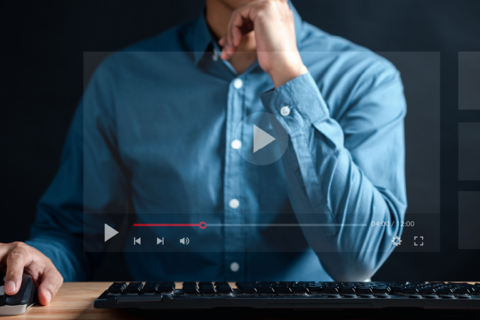 Someone contemplating at their computer. The screen is transparent, and we can see the play features for YouTube on the screen.